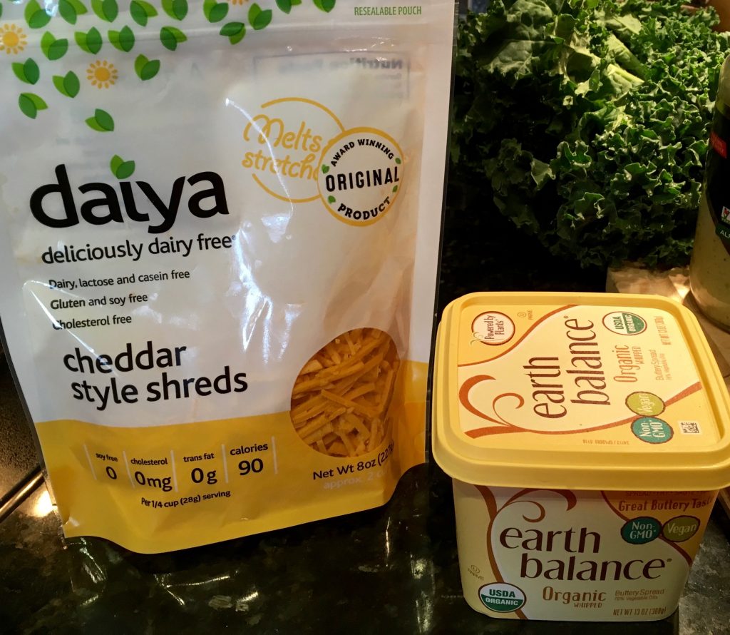 An image of a container of Earth Balance fake-butter and a bag of Daiya dairy free chedar cheese.