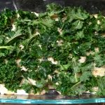 An image of a potato and kale casserole in a glass dish.