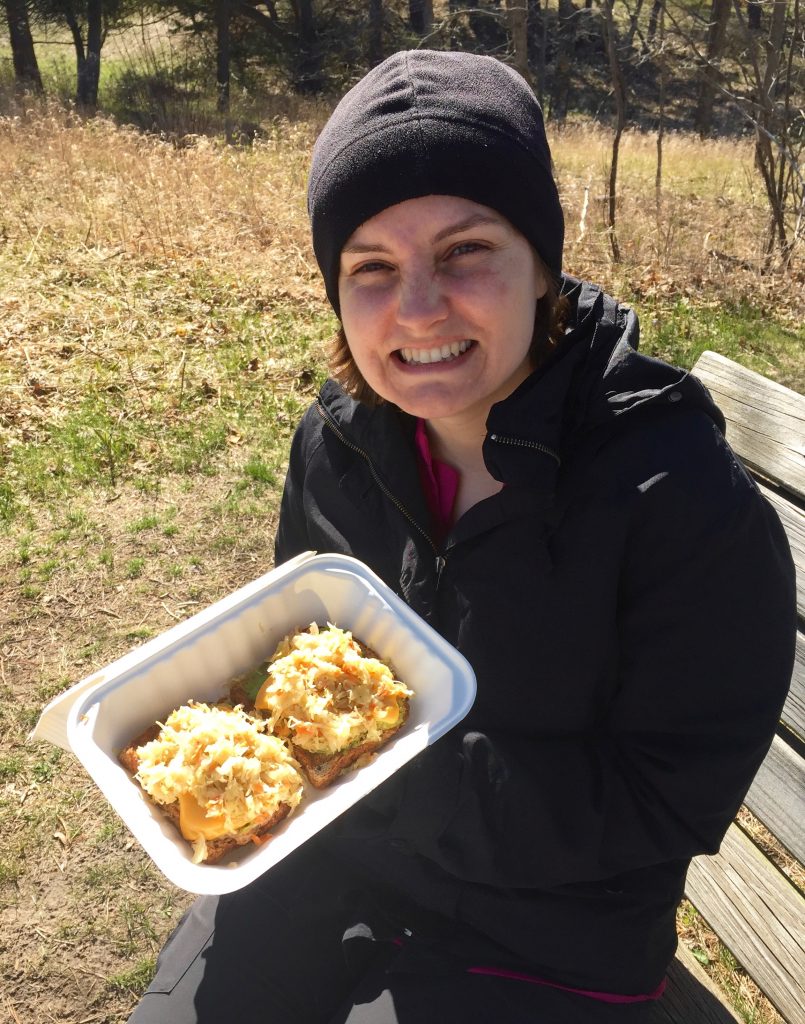 Photo of Beth with lunch food from Urban Beets (open-faced avocado reuben sandwiches).