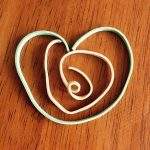Photo shows snapped rubber bands positioned in the shape of a heart.