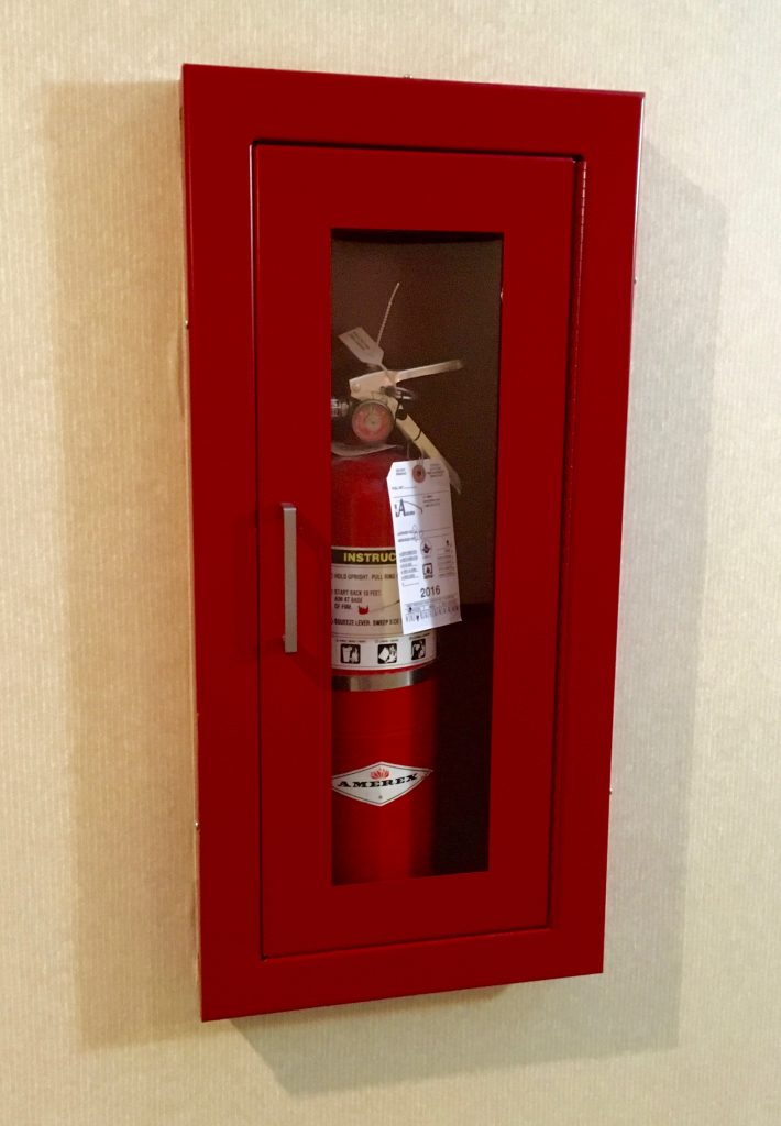 An image of a red canister of fire retardant in it's sealed metal, red box on a wall.