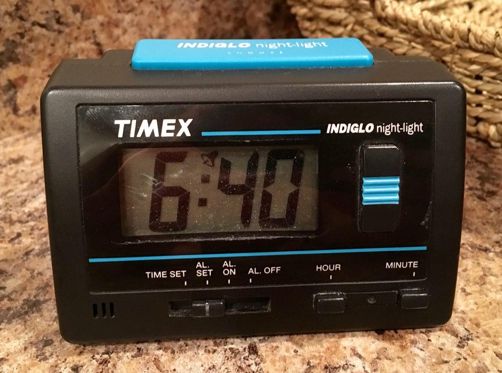 A black plastic alarm clock reading 6:40 with blue accents.