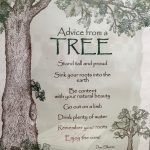 An art print of a large brown tree with leaves and a smaller tree in the foreground. The text on the print reads "Advice from a Tree, Stand tall and proud, Sink your roots into the earth, Be content with your natural beauty, Go out on a limb, Drink plenty of water, Remember your roots, Enjoy the View! Ilan Shamin."