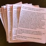 A stack of small pink papers with messages from bell hooks' "All About Love: New Visions."