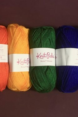 Skeins of yarn laid in a row: red, orange, yellow, green, blue, plum, purple.