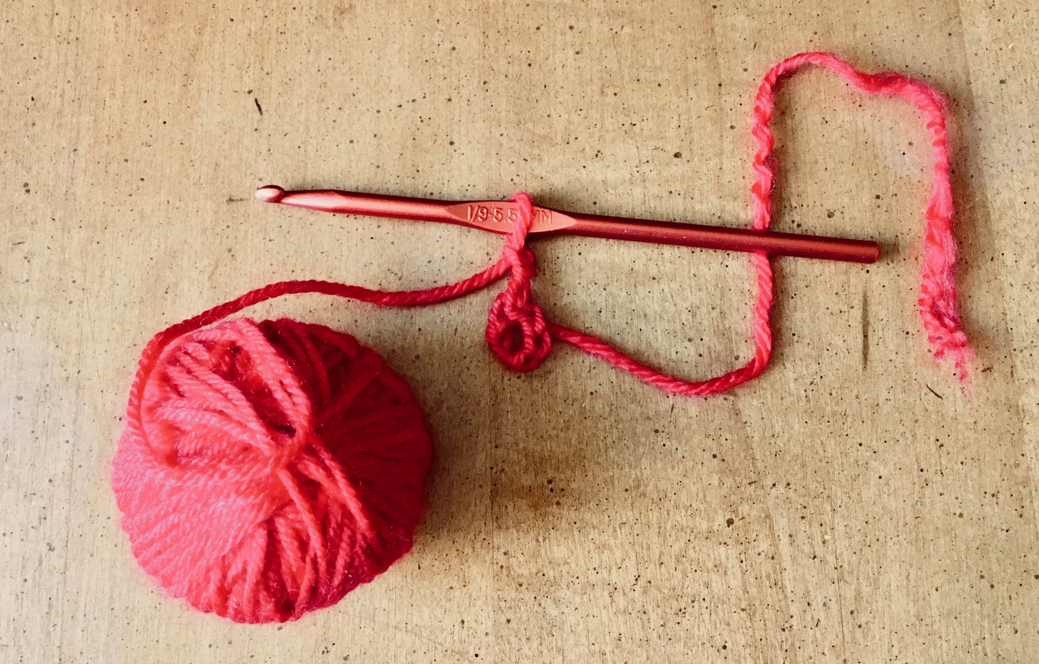 Red yarn cast onto crochet hook and chained into a circle.