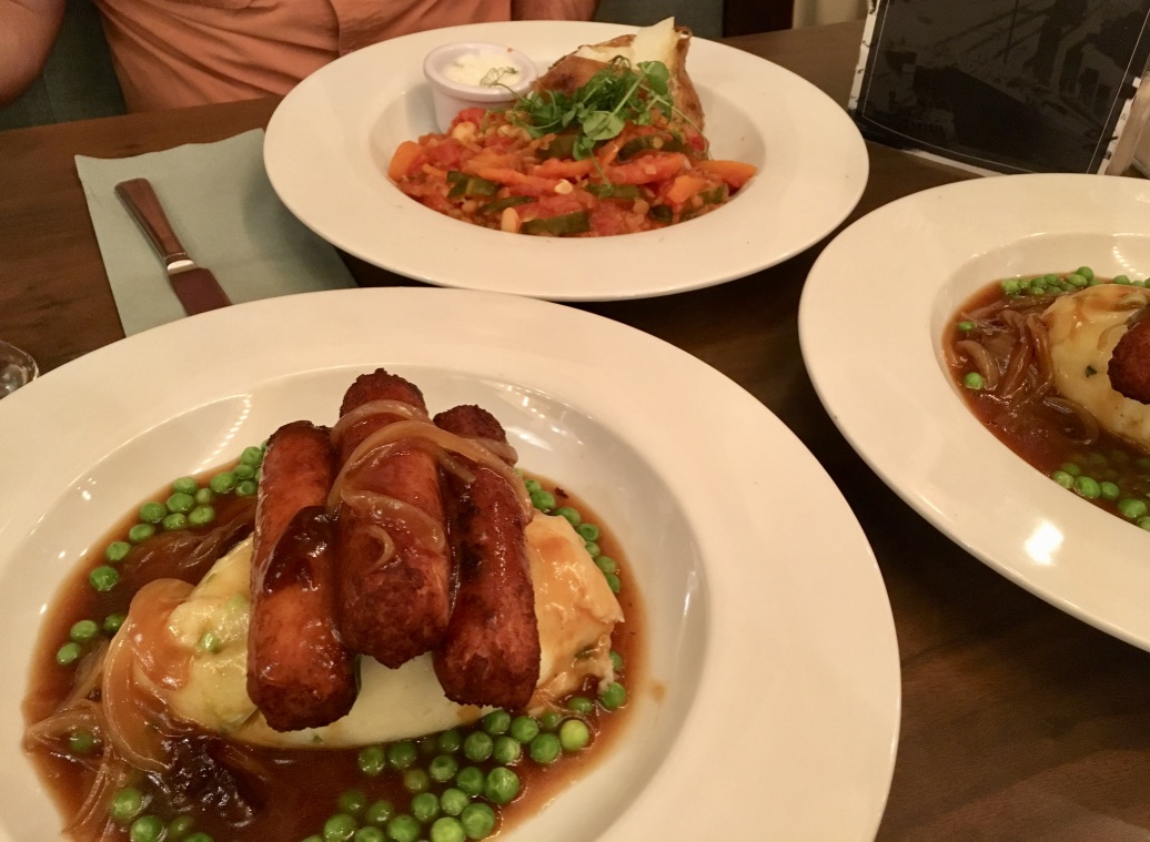 Traditional Irish food (bangers and mash) made vegan + gluten-free: jackfruit sausages, mashed potatoes, peas, onions, and mushroom gravy.