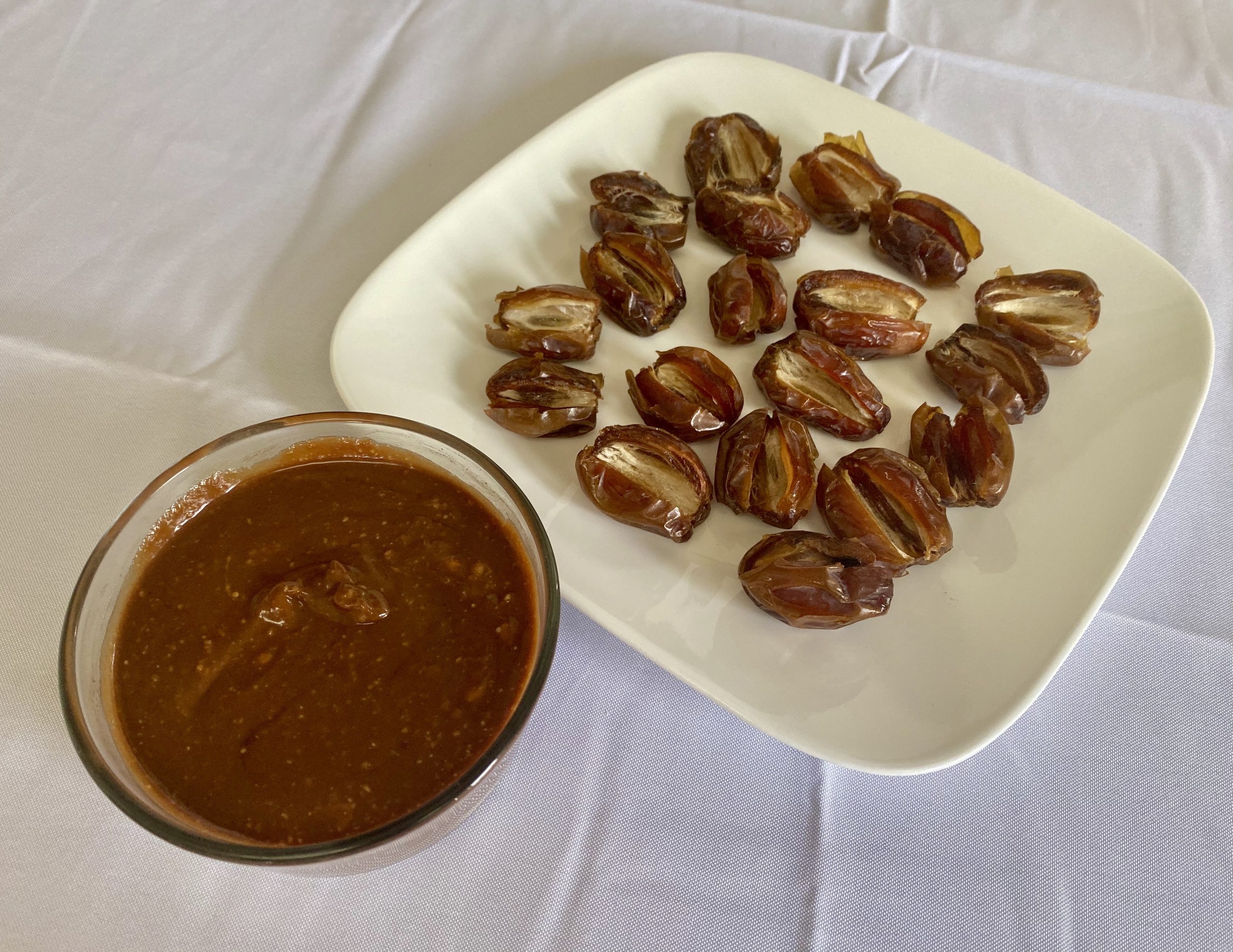 Dates with pits removed and ready to be stuffed with the creamy mixture of coconut cream, peanut butter, and melted chocolate. The mixture is dark brown from the chocolate—close to the color of the dates.