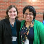 This photo from the 2014 Watson Conference shows the two of us—Beth Godbee (left) and Rasha Diab (right)—standing side-by-side; wearing a mix of blue, black, and green; in front of a brick wall.