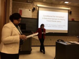 This photo from the 2016 Watson Conference shows the two of us—Rasha Diab (left) and Beth Godbee (right)—co-presenting: both with heads down, reading notes, standing at the front of a classroom.