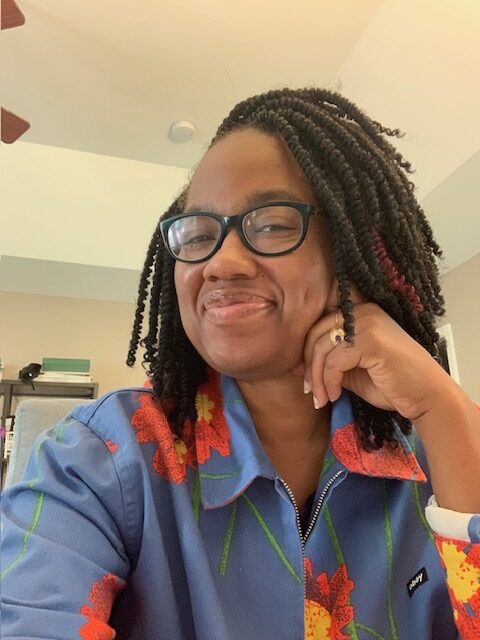 Photo shows a close-up of Candace Epps-Robertson, Ph.D. with head tilted to the side and smiling.