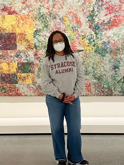 Candace Epps-Robertson at the Virginia Museum of Fine Art, standing in front of Sam Gilliam's painting, Of Cities American.
