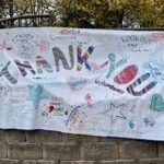 Colorful neighborhood sign that reads "THANK YOU volunteers" in large letters with lots of smaller text, hearts, and drawings. "Thank you to all of the helpers." and "Lookout says thank you!" and "Fenner Ave. says thank you helpers." and "Volunteers rock!" and more ...