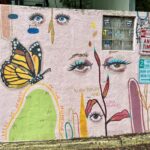 A a mural in downtown Raleigh (from my recent visit to Candace Epps-Robertson, Ph.D.) shows writing out in the world with a combination of eyes, plants, and a butterfly, along with the text: "There is beauty in the mundane" and "slow down and look inwards." The colorful mural by @nadasink sits alongside street signs, stickers, and the alphabet written in the upper right-hand corner.