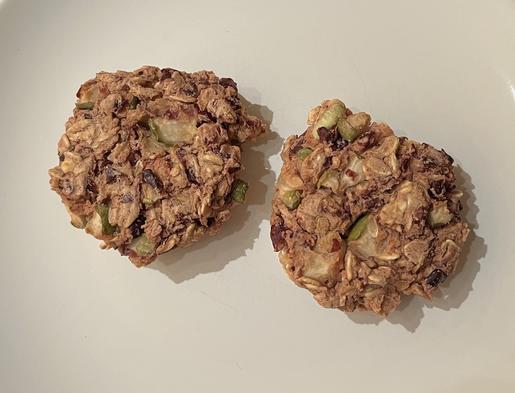 An image of two, circular veggie burgers that have been cooked and sit next to each other on a plate.
