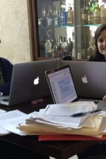 This photo is of Rasha Diab and Beth Godbee at the 2015 Conference on College Composition and Communication (CCCC), the year we presented “Toward a Richer Vocabulary of Power, Part of the Risk and Promise of Relational Work,” along with colleague Thomas Ferrel. We’re working in the hotel lobby with papers spread out and laptops open. We are both smiling.