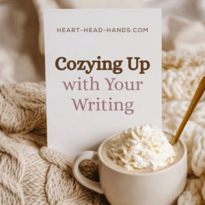 This ad for the workshop shows a thick knitted blanket and mug of hot cocoa with whipped cream and shares the title: "Cozying Up with Your Writing" and website: Heart-Head-Hands.com